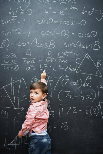 天才工作室拍摄年轻的男孩黑板上完整的数学方程