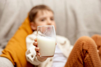 可爱的男孩坐着沙发上首页喝牛奶新鲜的牛奶玻璃乳制品健康的喝医疗保健源钙乳糖学前教育孩子休闲服装