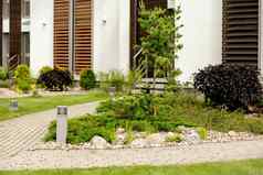 植物石头前面现代房子前面院子里景观设计美丽的花园现代城市生活住宅私人庭院绿色户外设施草坪上花园护理