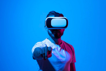 有胡子的男人。眼镜玩视频游戏虚拟现实耳机触摸手未来小工具技术研究视频游戏概念元宇宙