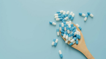 蓝白色抗生素胶囊药片木勺子蓝色的背景抗生素药物电阻处方药物医疗护理制药护理抗菌药物世界药剂师一天