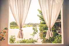 白色亚麻窗帘窗口视图绿色河树景观