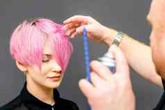 理发师头发喷雾修复短粉红色的发型年轻的高加索人女人头发沙龙