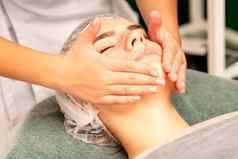 面部治疗按摩美丽的年轻的高加索人女人完美的皮肤接收脸脖子按摩美水疗中心