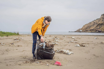 塑料垃圾海<strong>海洋污染</strong>海滩清洁年轻的男人。挑选塑料瓶沙子海岸环境积极分子收集垃圾保存地球自然保护