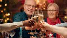 节日家庭无比的香槟眼镜享受圣诞节晚餐首页