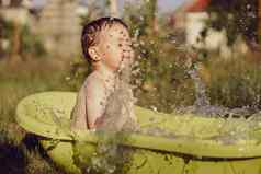 可爱的男孩洗澡浴缸在户外花园快乐孩子溅玩水有趣的夏天季节娱乐住很酷的夏天热水有趣的后院