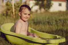 可爱的男孩洗澡浴缸在户外花园快乐孩子溅玩水有趣的夏天季节娱乐住很酷的夏天热水有趣的后院