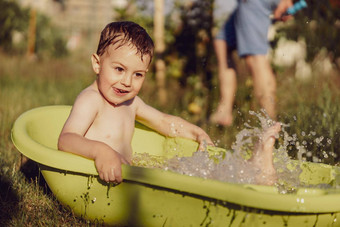 可爱的男孩洗澡<strong>浴缸</strong>在户外花园快乐孩子溅玩水有趣的夏天季节娱乐住很酷的夏天<strong>热水</strong>有趣的后院