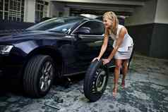 改变轮胎容易美丽的年轻的女人改变汽车轮胎parkade