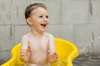 可爱的男孩洗澡黄色的浴缸在<strong>户外</strong>快乐孩子溅玩水有趣的<strong>夏天</strong>季节娱乐住很酷的<strong>夏天</strong>热水有趣的后院