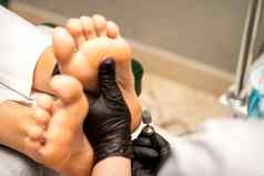 足穿黑色的保护手套清洁皮肤脚愈伤组织玉米专业电工具