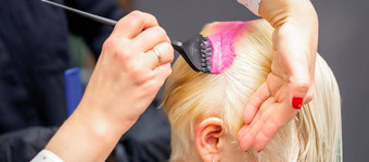 应用粉红色的染料刷<strong>白色头发</strong>年轻的金发女郎女人理发师沙龙