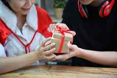 快乐亚洲夫妇持有开放圣诞节礼物盒子