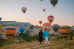 快乐年轻的夫妇日出看热空气气球卡帕多基亚卡帕多西亚火鸡