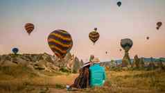 快乐年轻的夫妇日出看热空气气球卡帕多基亚卡帕多西亚火鸡