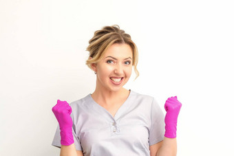 快乐高加索人女人医生穿粉红色的手套庆祝提高的拳头白色背景