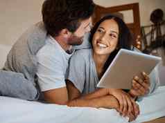 快乐夫妇微笑平板电脑卧室娱乐爱护理放松首页男人。女人微笑有趣的成键时间流媒体无线网络床上触屏技术