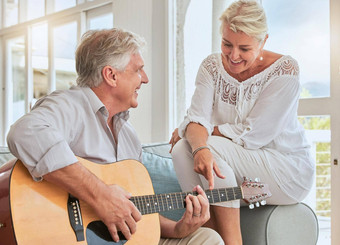 夫妇吉他爱首页沙发沙发上玩浪漫的可爱的感情音乐的首歌妻子浪漫退休高级男人。女人玩声字符串仪器生活房间