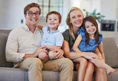 父母孩子们家庭肖像首页休息室沙发享受放松成键有趣的质量时间快乐父母微笑孩子们爱护理幸福快乐生活方式