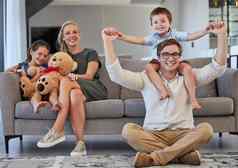 放松家庭沙发肖像首页年轻的父母孩子们成键周末好玩的小猪回来快乐人孩子们享受快乐的时间房子生活房间