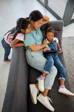 家庭平板电脑沙发放松妈妈。互联网孩子们快乐订阅服务显示科技快乐游戏网络房子姐妹看视频技术妈妈