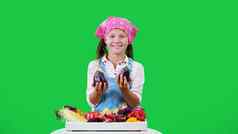 可爱的微笑农民女孩显示盒子新鲜的蔬菜收获绿色背景工作室健康的食物表格健康的营养