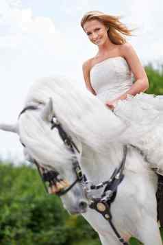 惊人的在骏马婚礼一天华丽的新娘摆姿势婚礼照片在白色马