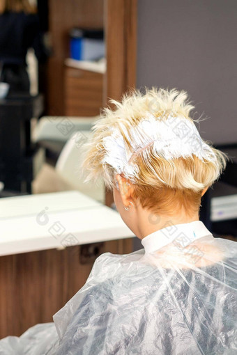 着色白色头发头发染料年轻的高加索人金发女郎女人坐着头发沙龙关闭