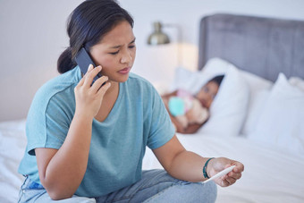科维德妈妈。调用卧室电话沟通医生孩子医疗保健焦虑担心强调菲律宾妈妈智能手机建议温度计阅读
