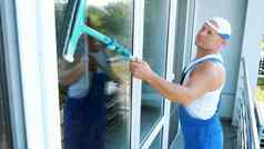 高加索人英俊的男人。工人清洁服务蓝色的工作服帽巴索清洁洗窗户特殊的拖把享受工作