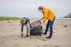爸爸儿子手套清洁海滩选择塑料袋污染海自然教育孩子们问题泄漏垃圾垃圾垃圾海滩沙子引起的人为造成的