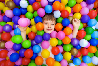微笑孩子说谎色彩斑斓的塑料球池游戏室孩子们球坑色彩斑斓的球干池幼儿园操场上孩子室内玩区域高加索人男孩室内操场上孩子们玩区孩子们区