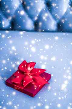 圣诞节假期奢侈品红色的礼物盒子蓝色的背景发光的雪闪闪发光的