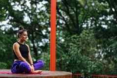 年轻的女人练习瑜伽坐着莲花位置