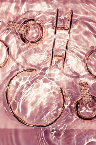 玫瑰黄金手镯耳环环Jewelery粉红色的水背景奢侈品魅力假期美设计珠宝品牌广告