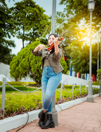 女人玩小提琴街肖像小提琴家女孩玩街女人艺术家玩小提琴在户外女孩说谎玩小提琴公园