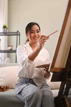 愉快的年轻的女人绘画图片水彩舒适的首页艺术有创意的爱好休闲活动概念