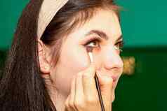 化妆过程手化妆艺术家适用于眼睛影子眼睛年轻的美丽的高加索人模型女人
