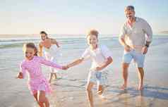快乐家庭运行海滩妈妈。父亲孩子们持有手夏天假期健康户外发展妈妈爸爸孩子们健康的有趣的能源海洋海波