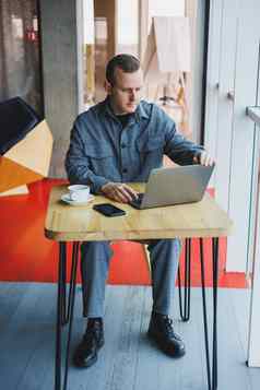 年轻的成功的商人西装饮料咖啡作品咖啡馆无线免费的互联网移动PC坐着表格咖啡馆