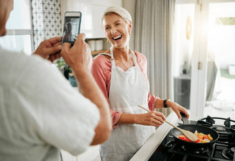 电话男人。女人采取图片烹饪健康的食物晚餐厨房快乐首页微笑社会媒体上了年纪的夫妇爱有趣的记忆享受质量时间