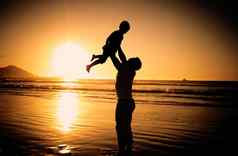 海滩轮廓黑暗日落家庭旅行假期毛里求斯快乐海洋海爱孩子假期夏天父亲孩子玩水自然阳光
