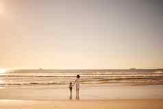 女孩妈妈。走水海滩日落夏天家庭假期年轻的女儿妈妈沙子海洋黄昏旅行假期模型空间