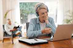 远程女人视频调用移动PC网络研讨会培训在线变焦调用会议首页办公室房子房间室内微笑快乐上了年纪的工人耳机工作启动科技面试