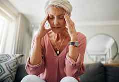 头疼疼痛焦虑高级女人思考精神健康问题生活房间沙发房子伤心上了年纪的人抑郁症首页压力沮丧退休沙发上