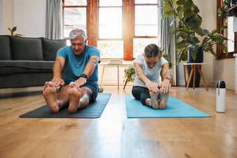 瑜伽伸展运动首页锻炼成熟的夫妇健身生活房间健康锻炼健康的生活方式澳大利亚高级男人。放松女人普拉提培训能源强大的身体
