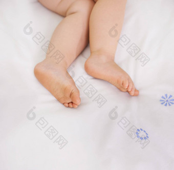 图片是清白的裁剪图像婴儿腿说谎床上