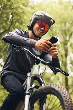 山自行车男人。自然电话全球定位系统(gps)地图方向冒险健身自行车打破森林快乐骑自行车体育运动员智能手机社会媒体打字位置搜索连接