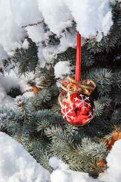 红色的圣诞节球挂云杉树分支机构覆盖雪